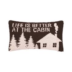 a black and white pillow with the words life is better at the cabin on it