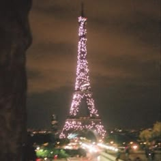 the eiffel tower is lit up at night with lights on it's sides