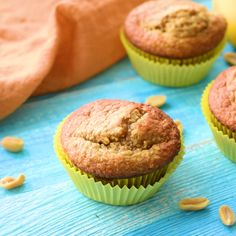 three muffins sitting on top of a blue table next to bananas and other food