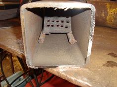 an old metal box sitting on top of a table next to some wires and other items