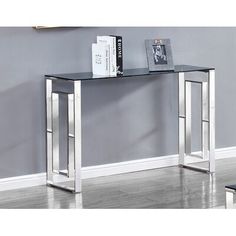 a black and silver console table with books on it