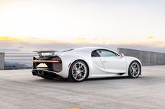 a white sports car parked on top of a parking lot