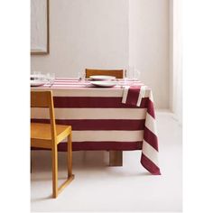 a dining room table with a red and white striped table cloth on it, next to a yellow chair