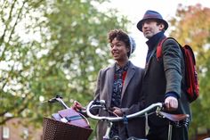 two people standing next to each other with bicycles