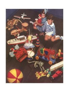 two children sitting on the floor surrounded by toys