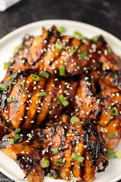 chicken with sesame seeds and green onions served on a white plate, ready to be eaten