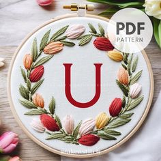 the letter u is surrounded by flowers and leaves on a white background with text overlay