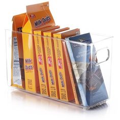 a stack of books sitting inside of a clear container on top of a white surface