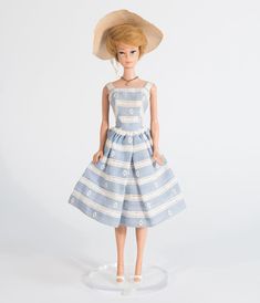 a doll wearing a blue and white dress with a straw hat on it's head