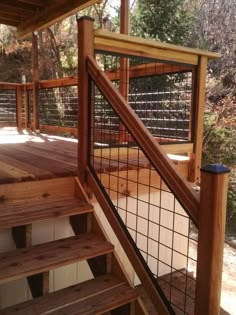 a wooden deck with metal railing and handrails