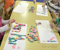 children are sitting at a table making crafts with colored paper and construction paper on it