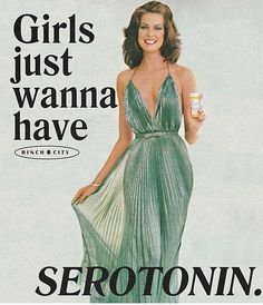 a woman in a green dress is holding a bottle and posing for a magazine advertisement