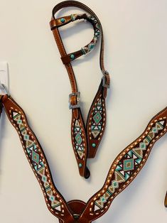 a pair of brown leather stirs with turquoise and white beaded designs on them