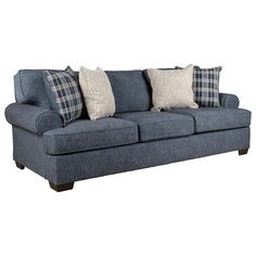 a blue couch with three pillows on it and two throw pillows sitting on the back