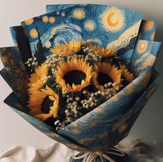 a bouquet of sunflowers wrapped in blue paper with the painting's starry night background