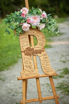 a wooden easel decorated with flowers and the word love written in cursive writing