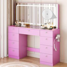 a pink vanity with mirror and lights on it in front of a white wall next to a rug