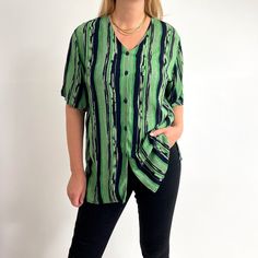 Relaxed, loose arty stripe print ladies shirt with a collar-less v-neck, side slits and short sleeves. Made from breathable, crinkled viscose in beautiful, juicy apple green and black. Large size, works as oversized, too. Worn in photos by 176cm tall, size 12UK. Perfect for a relaxed look over leggings or tied short to go with denim shorts. Made by Berkertex. 100% viscose. Medium size, labelled as 12UK. Measurements when laid flat are: Pit to pit: 56cm Waist: 56cm Length: 75cm Excellent conditio Retro V-neck Relaxed Fit Top, Oversized V-neck Shirt For Summer, Green Relaxed Fit V-neck Blouse, Retro V-neck Summer Shirt, Retro V-neck Summer Blouse, Trendy V-neck Relaxed Fit Blouse, Spring Striped V-neck Shirt, Trendy Striped Short Sleeve Blouse, Striped V-neck Shirt For Summer