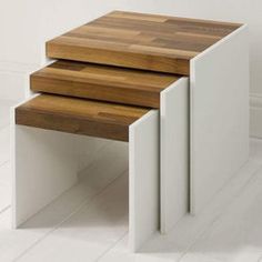 three wooden tables stacked on top of each other in the middle of a white room