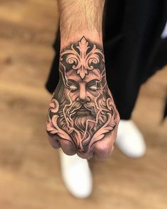 a man's hand with a tattoo on it