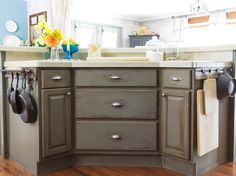 a kitchen island with pots and pans hanging from it's hooks on the door