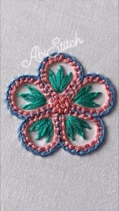 an embroidered flower with green leaves is shown on a gray background and has the words alot stitch written in it