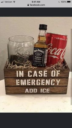 a wooden box filled with liquor and an empty glass sitting on top of a table