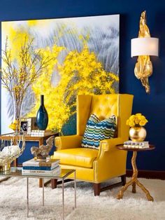 a living room with blue walls and yellow chairs in the corner, paintings on the wall