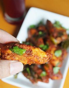 a person holding up some food on a plate