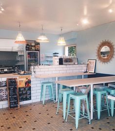 the inside of a restaurant with tables and stools