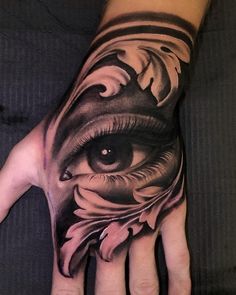 a person's hand with an eye and flower tattoo on the left palm,