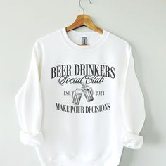 a white sweatshirt with the words beer drinkers special club printed on it, hanging from a wooden hanger