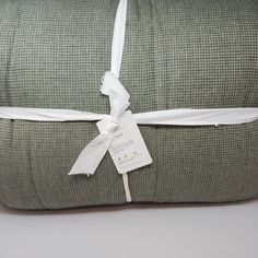 a green and white blanket wrapped in twine with a tag tied to the end