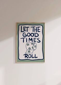 a white wall with a sign that says let the good times roll and toilet paper on it