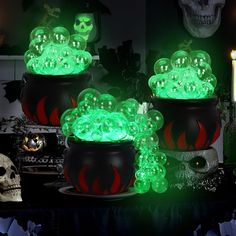 three potted plants with glowing green lights in the center and skulls on the side