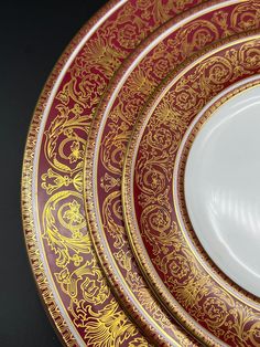 three red and gold plates stacked on top of each other in the shape of an ornate design