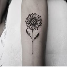 a black and white photo of a sunflower on the arm