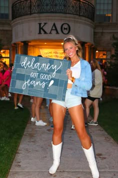 a woman in short shorts holding a sign