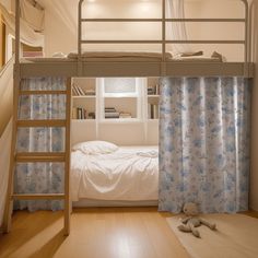 there is a bunk bed with curtains and a ladder in the room that has a stuffed animal on the floor