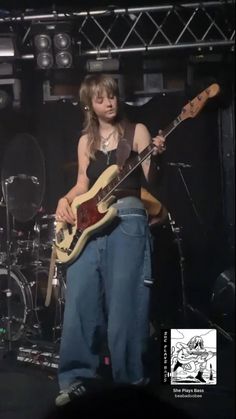 a woman playing guitar on stage at a concert