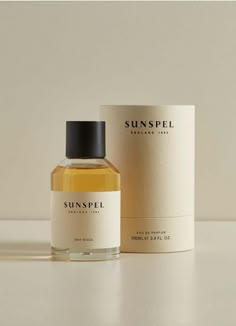 a bottle of sunspell cologne sitting on top of a white table next to a box