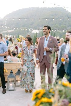 a group of people standing next to each other near a table filled with food and drinks