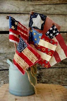 an old watering can is decorated with american flags