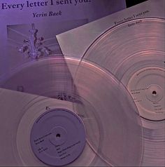 two silver records sitting next to each other on top of a purple sheet with the words every letter i sent you written on it