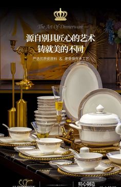 a table topped with lots of white dishes and gold trimmings on top of it