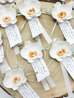 white orchids are arranged on top of each other with paper tags attached to them