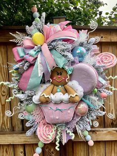 a wreath made to look like a baby's first christmas ornament is hanging on a wooden fence