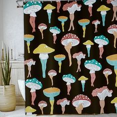 a shower curtain with colorful mushrooms on it in a bathroom next to a potted plant