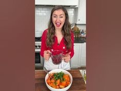 a woman holding a bowl with food in it and making a funny face at the camera