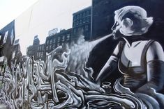 a large mural on the side of a building depicting a woman holding a fire hydrant